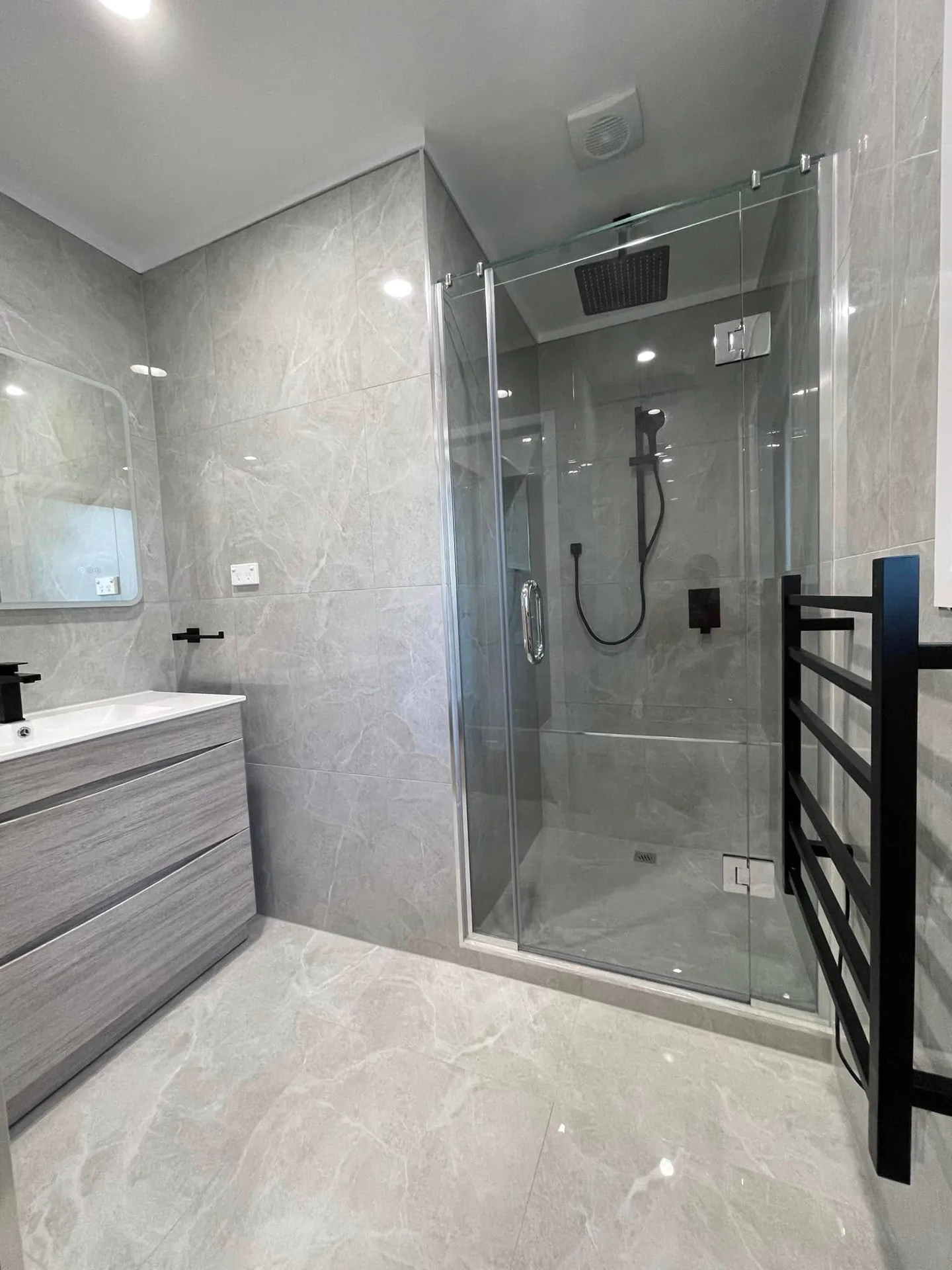 Modern glass shower enclosure with grey marble tiles