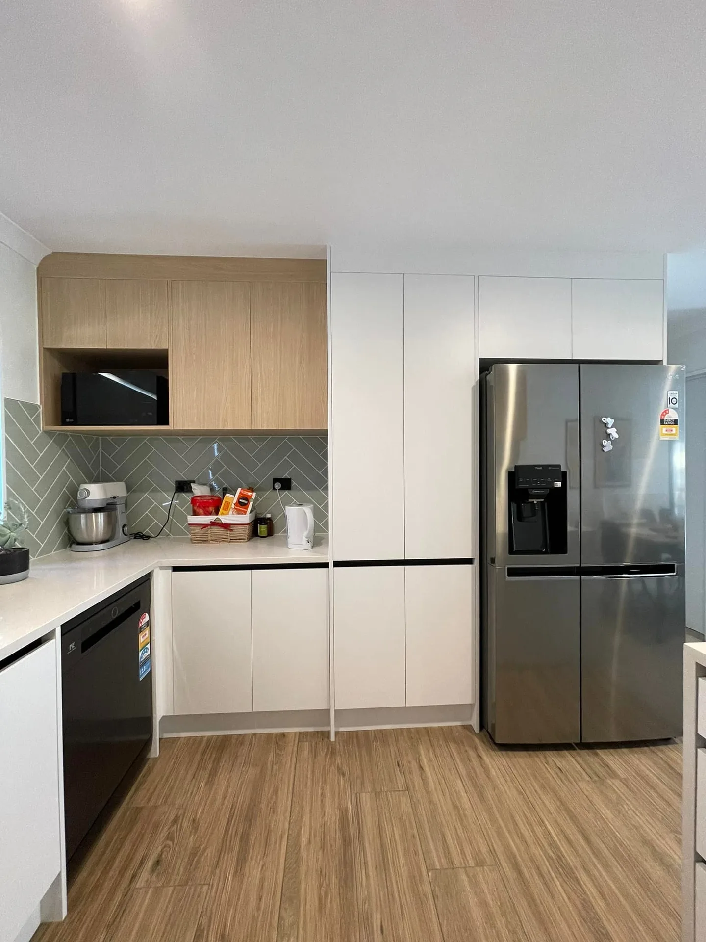 White kitchen with timber accents and herringbone tile splashback